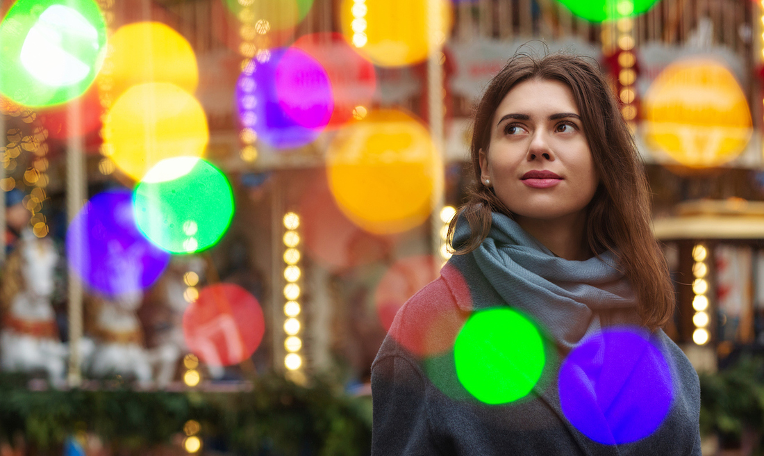 Dreaming woman wears grey coat walking at the casino street with bokeh light.